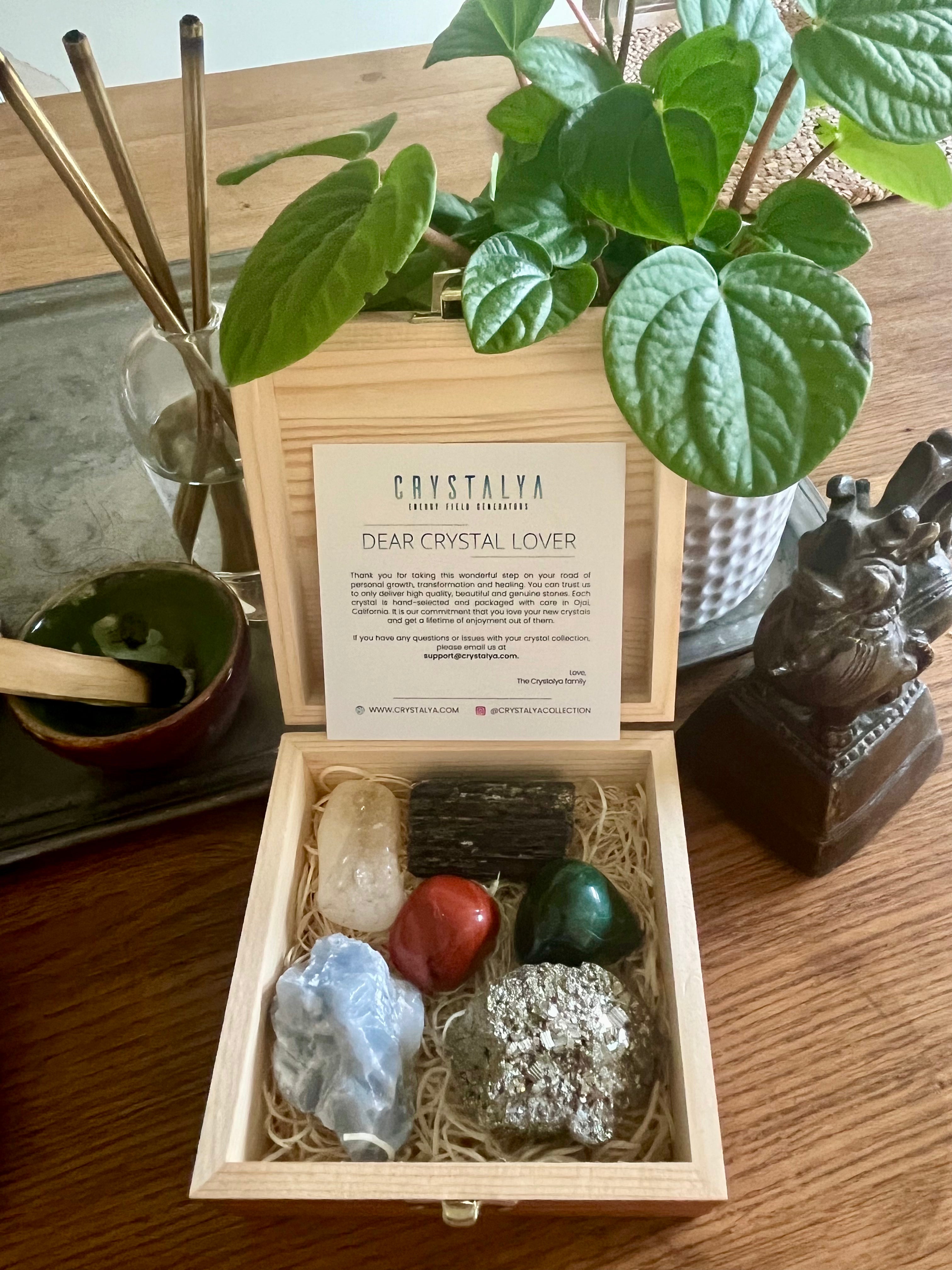 Feng Shui Crystal Set in engraved wooden display box showcasing pyrite, black tourmaline, citrine, red jasper, malachite and blue calcite.